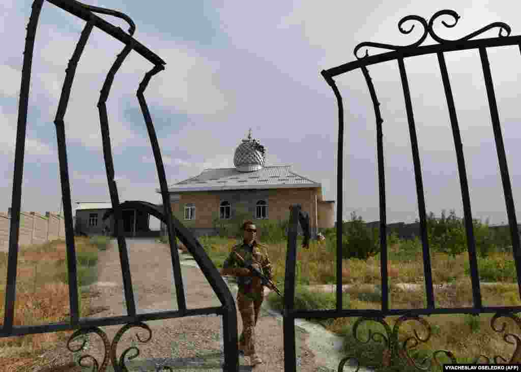 A Kyrgyz soldier patrols near a damaged mosque in the village of Maksat near the border with Tajikistan.&nbsp;