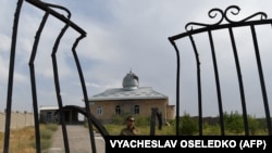 A Kyrgyz soldier patrols near a damaged mosque in the village of Maksat near the Kyrgyz-Tajik border after deadly clashes broke out in the region earlier this month. 