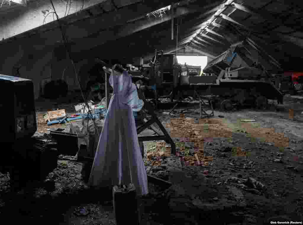 A wedding dress is seen near a destroyed Russian multiple rocket launch system inside a farm in the village of Nova Husarivka, recently liberated by the Ukrainian Army in the Kharkiv region.