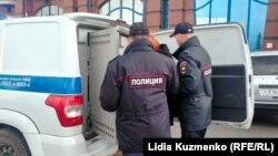 Полиция в Томске сажает в автомобиль задержанную активистку (архивное фото)