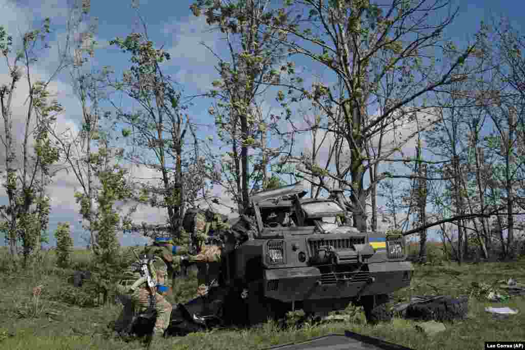 Ukrainian National Guardsmen pull the body of a Ukrainian fighter out of a damaged vehicle.&nbsp; In total, the remains of seven Ukrainian soldiers were retrieved during the recovery operation in and around the site of an apparent close-range battle in open landscape.