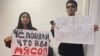 Qarakoz Qasym (left) and Aisultan Qudaibergen were detained at Almaty airport while holding posters saying: "Did you realize that you are cannon fodder?" and "Either respect or go away."