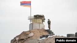 An Armenian soldier stands guard at a military post near the border with Azerbaijan (file photo).