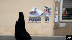 Një grua shihet duke ecur përreth materialeve të publikuara për fushatë për zgjedhjet parlamentare të Iranit, që mbahen më 1 mars.

