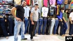 Иранцы позируют в джинсах в магазине по продаже одежды в Тегеране. 7 октября 2013 года.