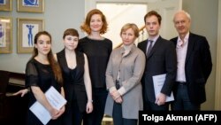 Composer Anthony Bolton (right); Olivia Ray (third from left), who plays the role of Anna Politkovskaya; Marina Litvinenko (third from right), Aleksandr Litvinenko's widow; and musicians pose for a photo during the press launch of the opera in London on February 24.
