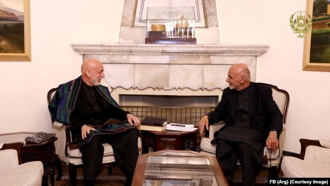 محمد اشرف غنی رئیس جمهور افغانستان (راست) حین صحبت با حامد کرزی رئیس جمهور اسبق این کشور