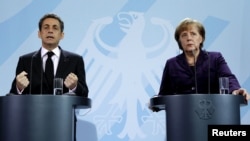 German Chancellor Angela Merkel (right) and French President Nicolas Sarkozy address a news conference following their talks at the Chancellery in Berlin on January 9.