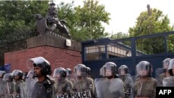 Iranian riot police stand guard outside the British Embassy in Tehran as hard-line students demonstrate.