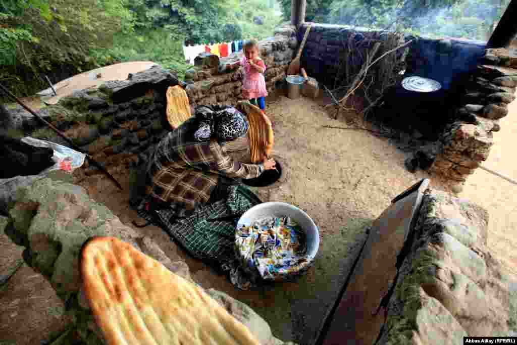 In the village of Astara, a woman bakes tandir bread with a traditional clay oven dug into the ground. 