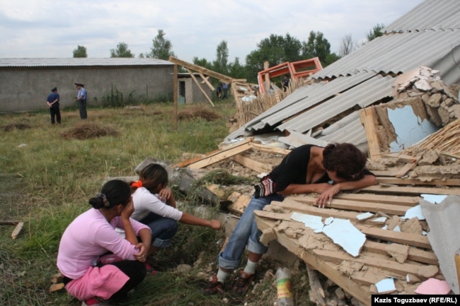 Проживавшая в поселке Бакай женщина рыдает на развалинах своего дома. Алматы, 7 июля 2006 года