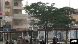 An image grab taken from a video posted on YouTube on May 20 showing Syrian soldiers chasing protesters in Hama, north of Damascus.