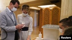 Сирия президенті Башар Асад (сол жақта) және әйелі Асма. 