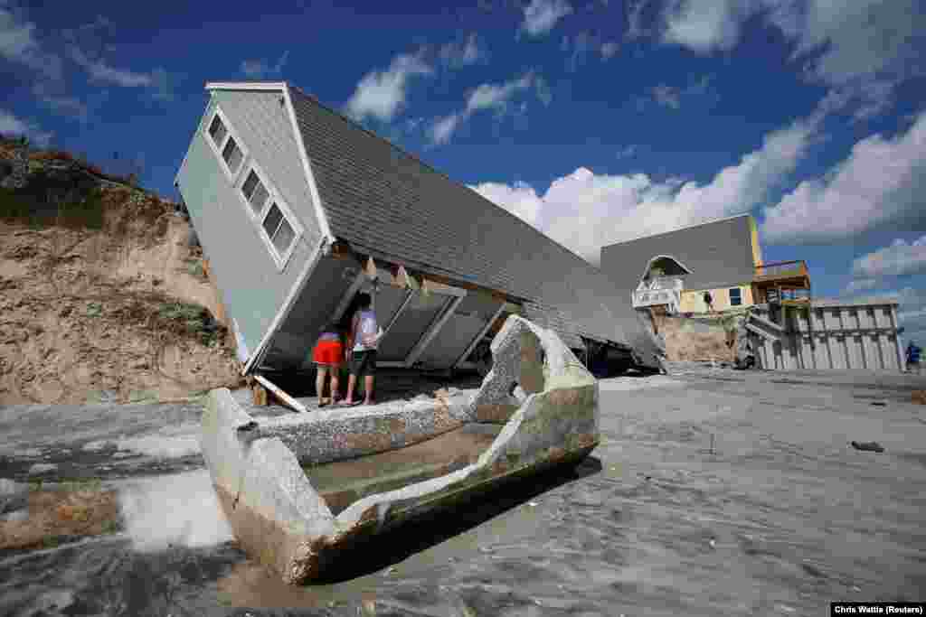 Local residents look inside a collapsed coastal house after Hurricane Irma passed an area in Vilano Beach, Florida. (Reuters/Chris Wattle)
