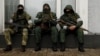 Armed men wearing masks are seen in the center of Luhansk on November 22.