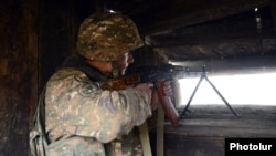 Armenia - A soldier with a machine gun at an Armenian army outpost on the border with Azerbaijan, 27Nov2013.