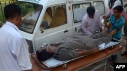 Pakistani paramedics shift a liquor victim to a hospital in Karachi on October 8, 2014.