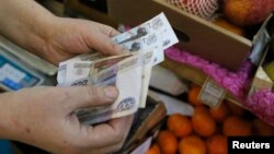 Продавец на рынке пересчитывает рубли. Москва, 3 марта 2014 года.