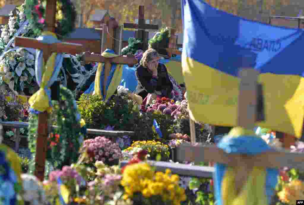 A relative reacts at the cemetery where buried Ukrainian servicemen and volonteers died during the war in the east of the country, marking the All Saints Day, in the western city of Lviv, on Novemeber 1. (AFP/Yuriy Dyachyshyn)