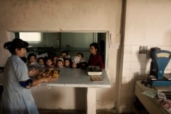 Schoolchildren being served a lunch of sandwiches and deep-fried bread at a school in Bukhara in 2010