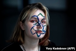 Darya Kozlova, an activist protesting against facial recognition, has her face painted with geometrical shapes and lines said to confuse cameras, in Moscow in February 2020