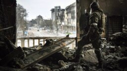A Russian soldier stands in the Mariupol Drama Theater, which was bombed by Russian forces on March 16 with civilians sheltering inside, with estimates of the resulting casualties reaching into the hundreds.