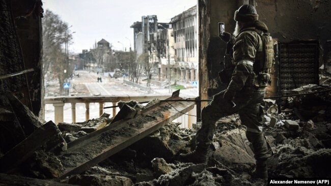 A Russian soldier stands in the Mariupol Drama Theater, which was bombed by Russian forces on March 16 with civilians sheltering inside, with estimates of the resulting casualties reaching into the hundreds.