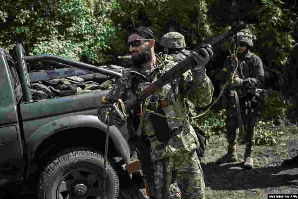 Ushtarët ukrainas duke u përgatitur të lëvizin drejt vijës së frontit në një pikë kontrolli në rajonin lindor ukrainas të Donbasit, më 23 maj 2022, mes pushtimit rus të Ukrainës.