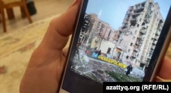 Людмила Мырзагалиева показывает на смартфоне фотографию разрушенного дома, где на четвертом этаже находилась ее квартира. Это фото ей прислали соседи из украинского Мариуполя. Атырау, 22 мая 2022 года