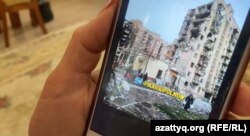 Liudmila Mirzagalieva arată pe telefon o fotografie cu apartamentul ei, la etajul patru al blocului distrus din Mariupol. Această fotografie i-a fost trimisă de vecinii rămași în oraș. 22 mai 2022.