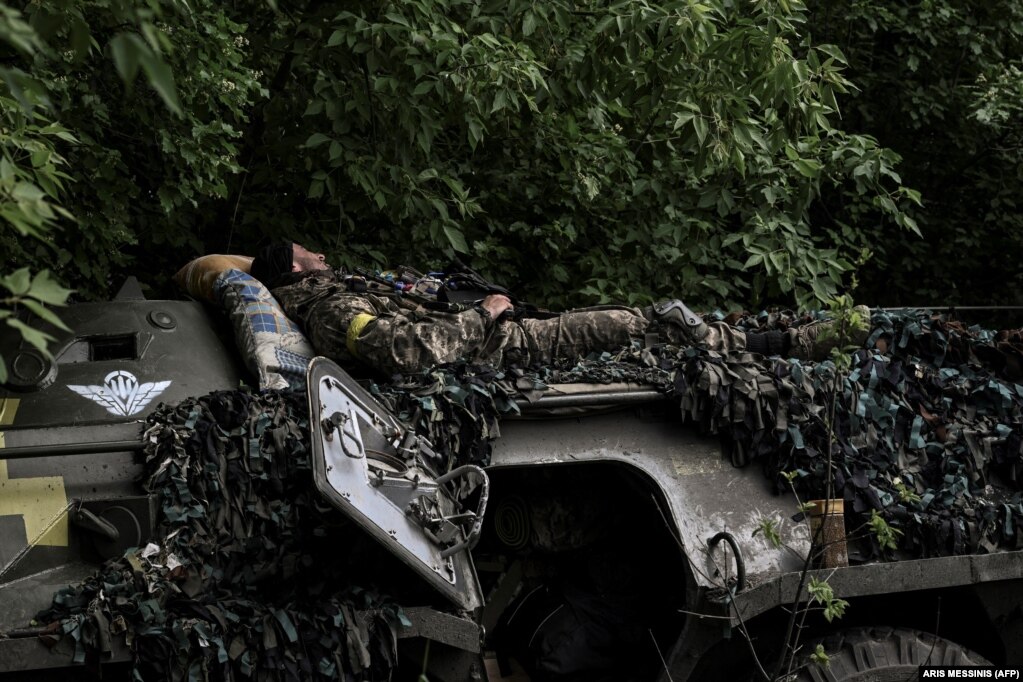 Një ushtar ukrainas duke pushuar para se të shkojë në vijën e frontit pranë qytetit Lysychanski.