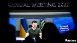 Ukrainian President Volodymyr Zelenskiy is seen on a screen as he delivers a video address to the delegates of the World Economic Forum in Davos on May 23.