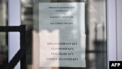 Different company names, among them the BAC Consulting KFT, are displayed at the entrance to the building housing them, on September 18 in Budapest.