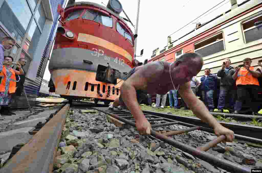 Athlete and powerlifter Ivan Savkin pulls a train with several carriages, weighing a combined 120 tons, in the Russian Far East city of Vladivostok. (Reuters/Yuri Maltsev)