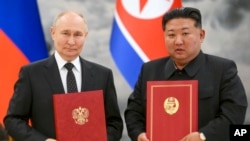 Presidenti rus Vladimir Putin (majtas), dhe lideri i Koresë së Veriut, Kim Jong Un, gjatë një ceremonie të nënshkrimit të partneritetit të ri në Phenian, Koreja e Veriut, më 19 qershor 2024.