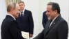 Vladimir Putin Kremldə danışıqlardan əvvəl Abbas Ərağçini salamlayır.