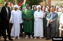 صادق المهدی (نفر دوم از چپ) و حسن الترابی (وسط) در مراسم تشییع محمد ابراهیم نُقُد سیاستمدار سودانی و رئیس حزب کمونیست سودان در سال ۲۰۱۲