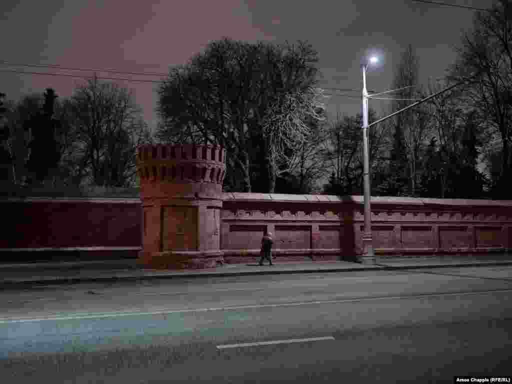 A woman walks past Novodevichy&#39;s walls after 5 p.m., when the cemetery gates close. Only the occasional patrol of a security guard breaks the stillness inside until it reopens at 9 a.m. the next morning.&nbsp; &nbsp;