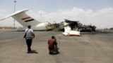 Media photographers take pictures of a destroyed plane at Sanaa International Airport in the aftermath of an Israeli airstrike earlier this month. 