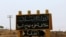 FILE: An Islamic State group banner showing an arrow towards the town of Tabqa in Syria.