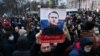 A protester holds up an image of Aleksei Navalny saying "Free Navalny!" at a march in support of the jailed opposition leader in downtown Moscow in January 2021.