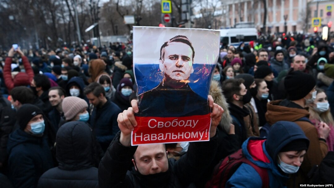 A protester holds up an image of Aleksei Navalny saying "Free Navalny!" at a march in support of the jailed opposition leader in downtown Moscow in January 2021.