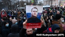 A protester holds up an image of Aleksei Navalny saying "Free Navalny!" at a march in support of the jailed opposition leader in downtown Moscow in January 2021.