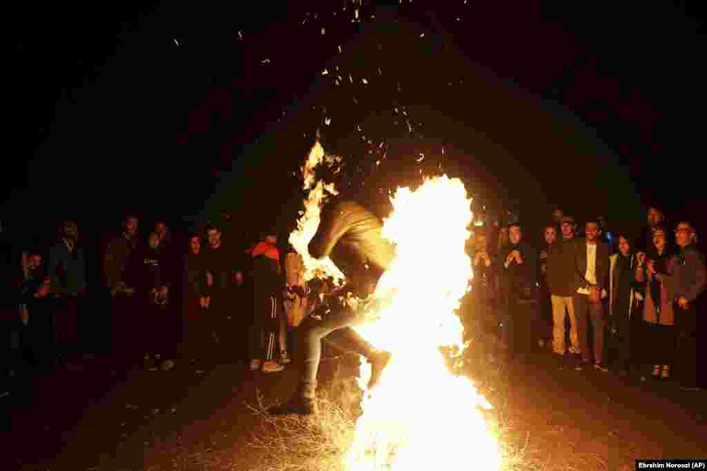 An Iranian man jumps over a bonfire during a celebration, known as &quot;Chaharshanbe Souri,&quot; or Wednesday Feast, marking the eve of the last Wednesday of the solar Persian year, Tuesday, March 19, 2019 in Tehran, Iran. &nbsp;