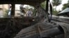 Luptatorii talibani investighează o mașină avariată după ce au fost trase mai multe rachete la Kabul. 30 august 2021.