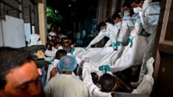 Healthcare workers carry the bodies of Iranian sailors who died in a US torpedo attack on their frigate off Sri Lanka's southern coast, at the mortuary of the Karapitiya hospital in Galle, on March 4.
