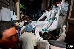 Healthcare workers carry the bodies of Iranian sailors who died in a US torpedo attack on their frigate off Sri Lanka's southern coast, at the mortuary of the Karapitiya hospital in Galle, on March 4.