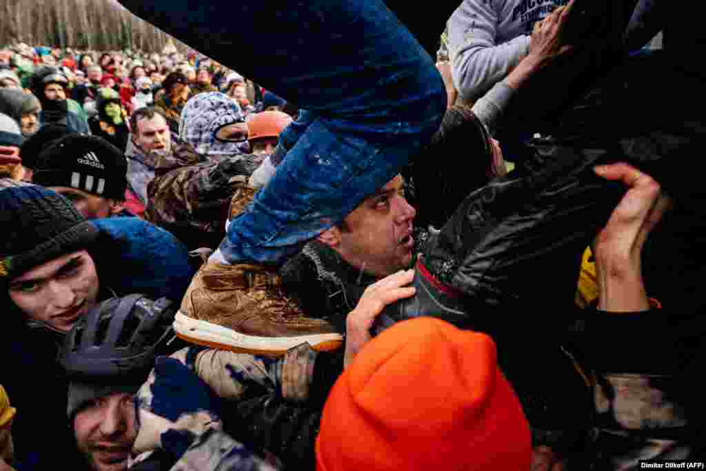 People storm a snow fortress during the celebrations of Maslenitsa or Shrovetide close to the village of Khlyupino, some 60 kilometers outside of Moscow, on March 1. Shrovetide or Maslenitsa, an ancient farewell ceremony to winter traditionally celebrated in Belarus, Russia, and Ukraine, involves the burning of a large effigy. (AFP/Dimitar Dilkoff)