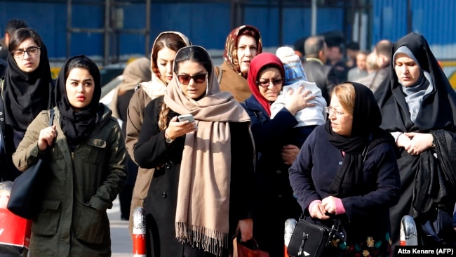Iranian women wearing hijab walk down a street in the capital Tehran, February 7, 2018