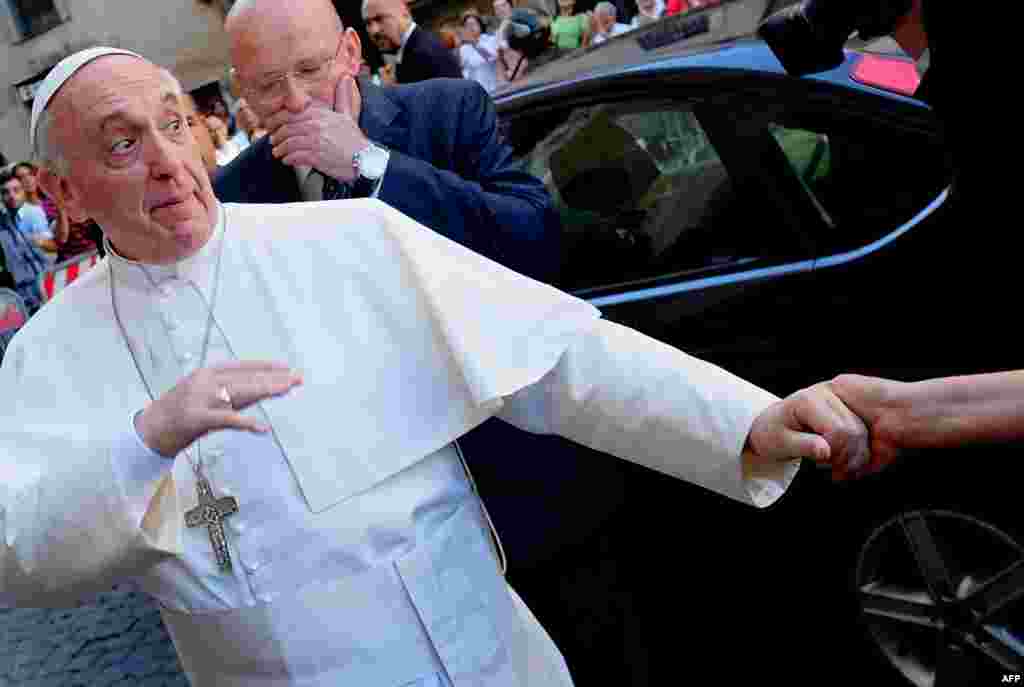 Pope Francis is greeted by the faithful as he arrives at the Chiesa Del Gesu in Rome. (AFP/Alberto Pizzoli)